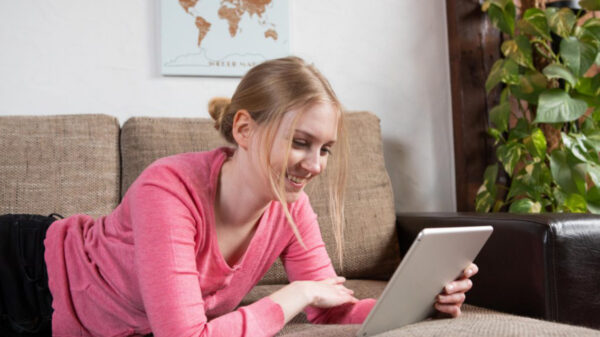 Studentin auf Sofa vor Laptop