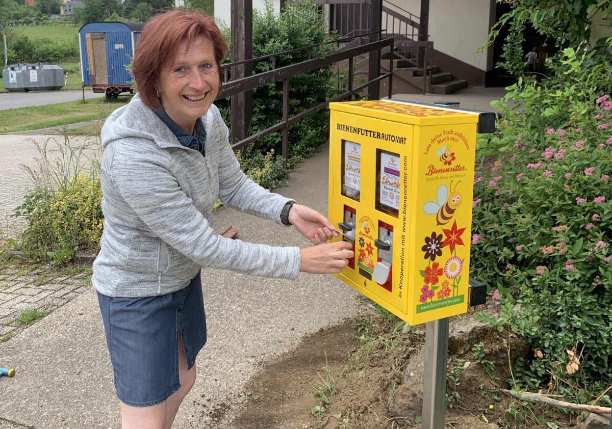 Frau an Bienenfutter-Automat