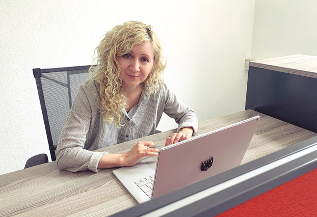 Frau an Schreibtisch vor Laptop