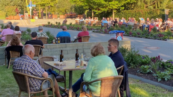 Menschen an Tischen in grüner Umgebung