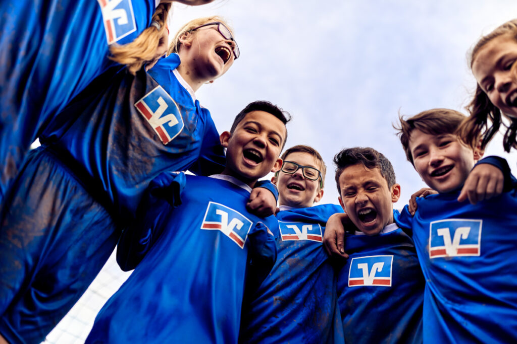 Kinder im Fußballtrikot stehen im Kreis