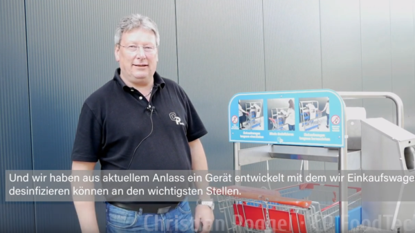 Mann steht vor Gebäude neben Gerät