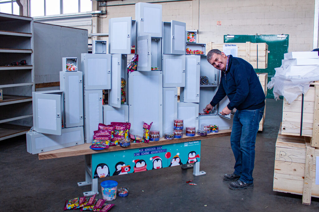 ein Mann steht vor einem gebauten Adventskalender