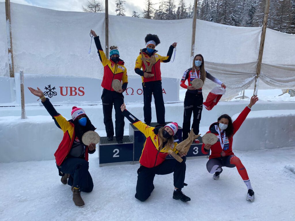 Bobfahrerinnen stehen um ein Podium