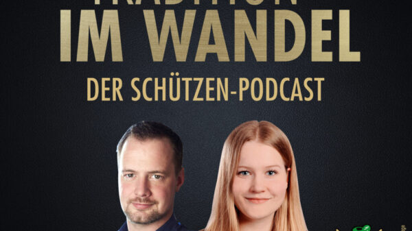 Goldene Schrift auf schwarzem Grund, darunter Portrait von Mann und Frau