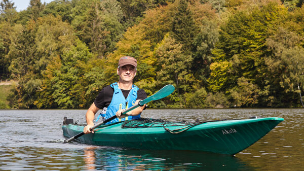 Mann rudert im Kayak