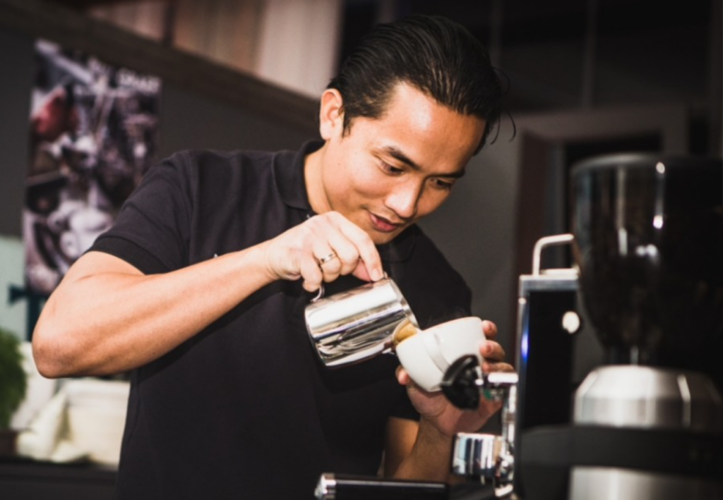 Mann gießt Kaffee in Tasse