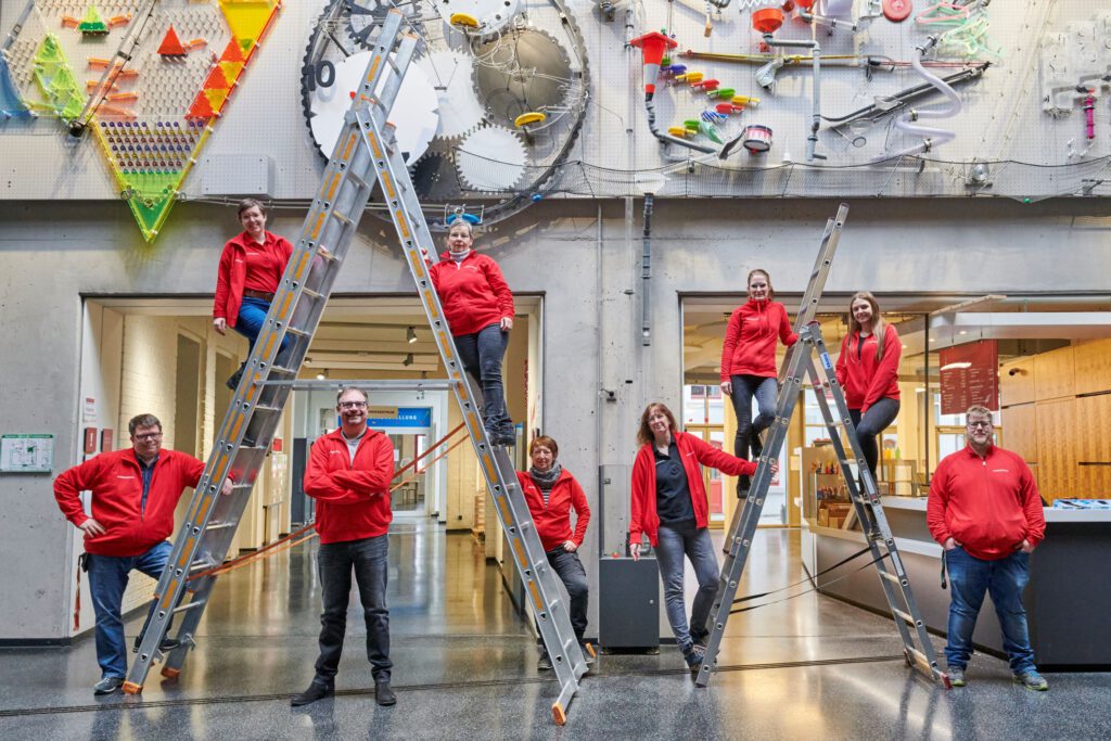 Team, welches auf zwei Leitern steht